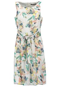 Robe blanche sans manches avec un motif floral multicolore et une ceinture en tissu nouée à la taille.