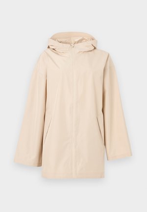 Veste de pluie beige à capuche avec une fermeture éclair intégrale à l'avant, coupe ample, deux poches latérales et matériau lisse et résistant à l'eau.