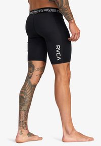 Schwarze, eng anliegende Sportshorts mit einem gestreiften Bund. Glatte Textur und keine sichtbaren Muster oder Details außer dem Logo.