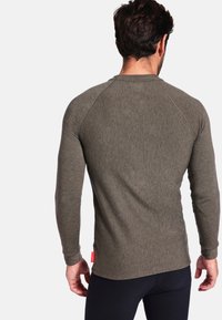 Langarmige, getailleerde overhemd in olijfgroen, met textuurstof, raglanmouwen, voorzien van een klein rood label aan de onderzijde.