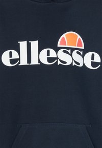 Mornaroplava dukserica s velikim bijelim logotipom i grafikom u narančastoj i crvenoj boji iznad. Mekani materijal s prednjim džepom.
