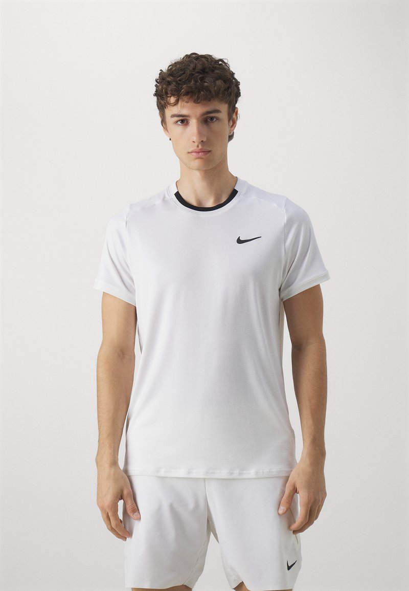 Hvit treningstrøye laget av glatt stoff, med korte ermer, svart rund hals, og en liten svart Nike-logo på brystet.