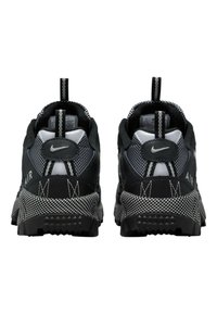 Zwarte sportschoenen van gestructureerd mesh en synthetisch leer, met een patroon op de zool, reflecterende accenten en dubbele trek-lussen voor gemakkelijk aan- en uittrekken.