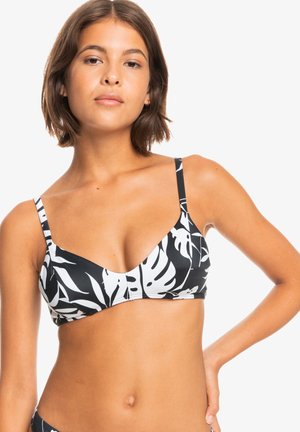 Black bikini top with white tropical leaf pattern, triangular shape, thin straps, smooth texture, suitable for swimwear.
