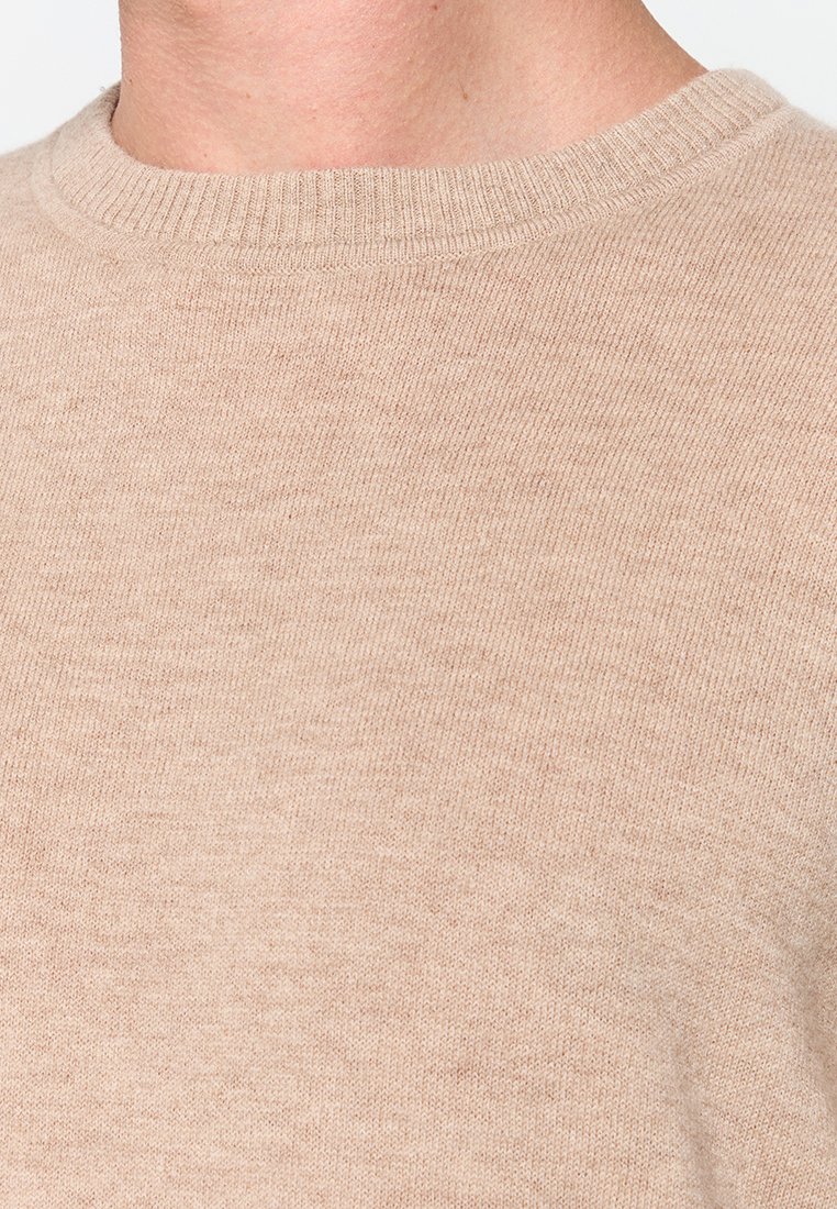 Beige Strickpullover mit Rundhalsausschnitt, gerippten Bündchen und Saum, mittlerer Dicke und weicher Textur, ideal zum Überziehen.