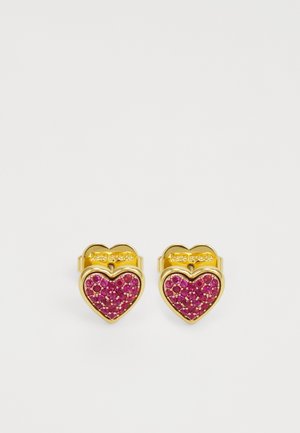 Guldtonade hjärtformade örhängen med rosa rhinestones, slät yta och en subtil märkning på toppen.