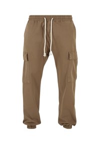 Pantalon cargo marron avec taille et poignets élastiques, cordon blanc et poches à rabat sur les deux cuisses.