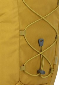 Fabricado con un tejido texturizado de color amarillo, presenta un cordón elástico en forma de cruz, un regulador gris y correas ajustables.