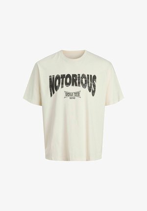 Cream oversized T-shirt made of cotton, featuring a black distressed print with "NOTORIOUS" and "WORLD TOUR 1990" text. Short sleeves, crew neck.