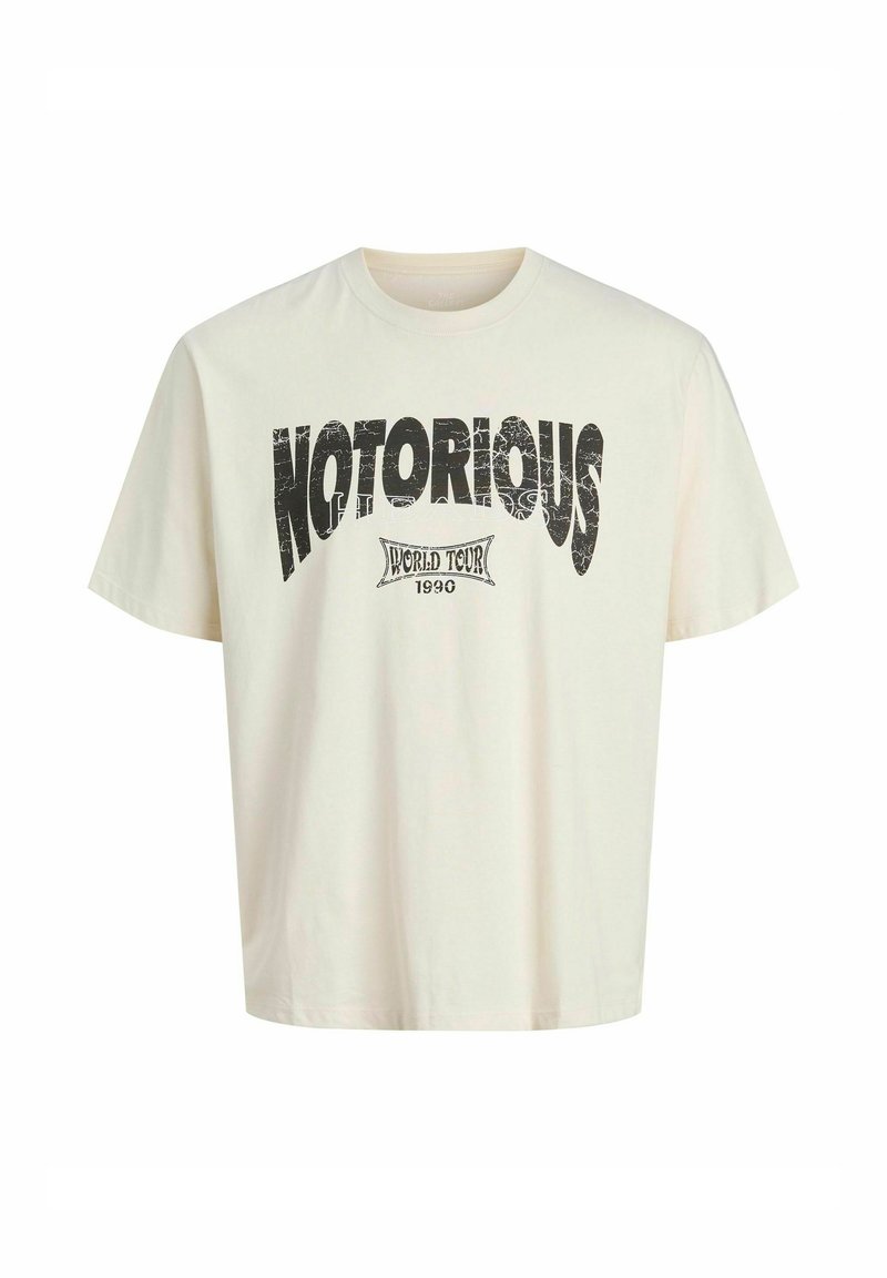 Krémové oversized tričko vyrobené z bavlny, s čiernym opotrebovaným potlačou „NOTORIOUS“ a textom „WORLD TOUR 1990“. Krátke rukávy, okrúhly výstrih.