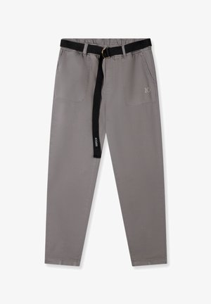 Grijze broek met een elastische tailleband en een zwarte riem. Voorzien van twee steekzakken aan de voorkant en minimalistische zijkanten. Gladde stoftextuur.