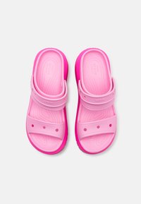 Sandale roz tip slip-on cu două curele late, talpă texturată și orificii pentru ventilație; talpa exterioară este de un roz mai închis pentru contrast.