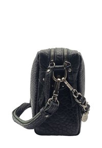 Sac bandoulière en cuir noir texturé avec ferrures en argent, double zip et bandoulière amovible présentant une étiquette métallique "mila louise Paris".