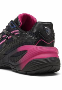 Svart atletisk sko med en rosa mellansula, övre del i mesh, plastdetaljer och en vadderad krage för komfort. Inkluderar en logotypdetalj på hälen.