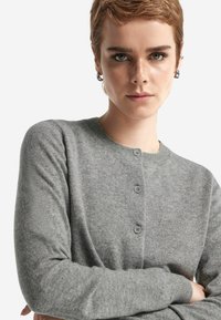Szary kardigan zapinany na guziki, wykonany z miękkiej wełny, z okrągłym dekoltem, ozdobiony trzema guzikami i delikatną fakturą.