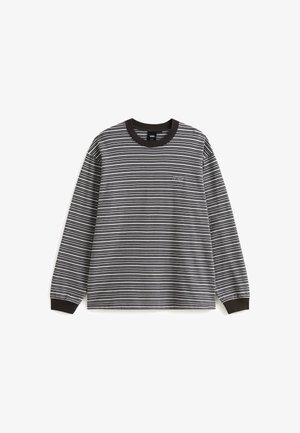 Halenka s dlouhým rukávem v černobílých pruzích, s vroubkovaným černým límcem a manžetami. Diskrétní značení na hrudi. Bavlněný materiál.