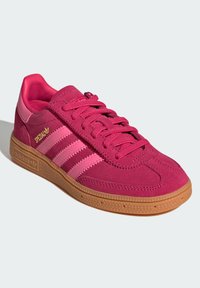 Rosa semsket sneakers med tre lyserosa striper, gummisåle og gulllogo detaljer. Har snøring og polstret krage.