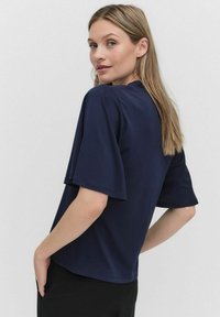 Marinblå kortärmad topp i avslappnad passform, med rund halsringning och mjukt tyg, med en slät yta och minimala designdetaljer.