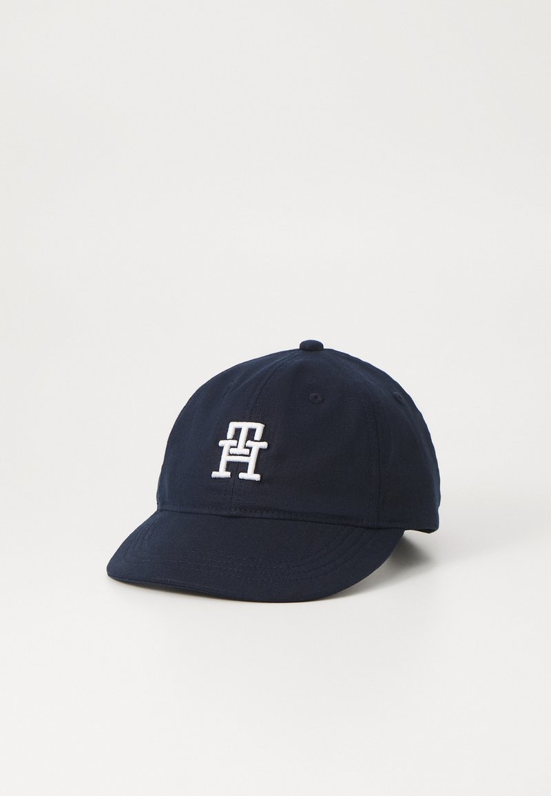 Cappellino da baseball blu navy realizzato in cotone, con visiera curva e logo bianco ricamato sulla parte frontale. Strappo regolabile sul retro.