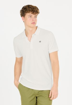 Valkoinen polo-paita, jossa on kaulus ja käännetyt lyhyet hihat, vasemmassa rinnan kohdassa on pieni musta logo. Silkkinen puuvillakudos, rento istuvuus.