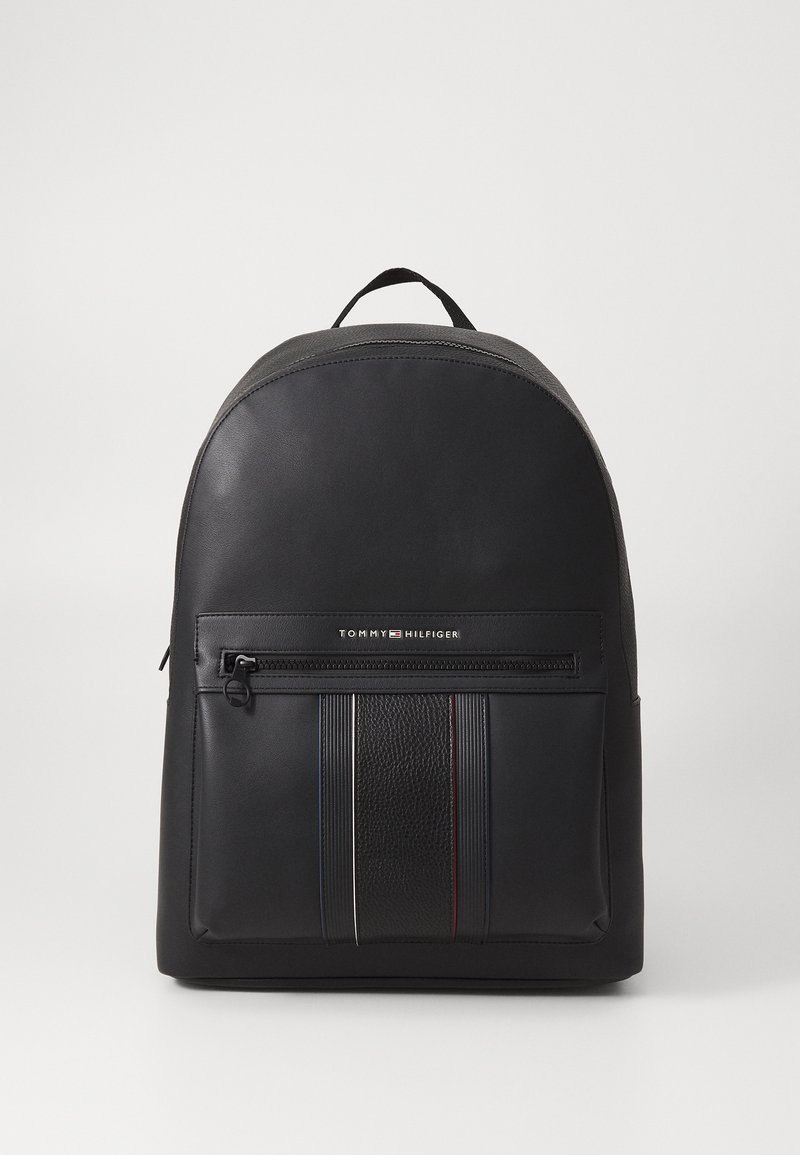 Mustat reppu, jossa on pyöreä muoto, valmistettu sileästä materiaalista. Varustettu edessä olevan vetoketjullisen taskun kanssa, jossa on teksturoitu yksityiskohta ja moniväriset raidat.