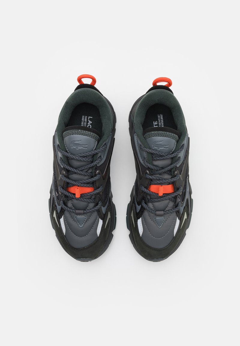 Zwarte en grijze sport schoenen met een combinatie van mesh en synthetische materialen, textuurzolen, oranje veters en een rubberen achterlip.