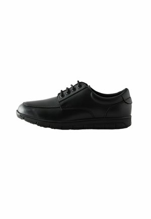 Chaussure en cuir noir avec un embout arrondi, texture lisse et six œillets. Elle dispose d'une semelle rembourrée avec un design segmenté pour plus de flexibilité.