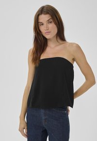Schwarzes strapless Oberteil aus leichtem Stoff mit geradem Ausschnitt, lockerer Passform und glatter Textur, kombiniert mit blauen Jeans.