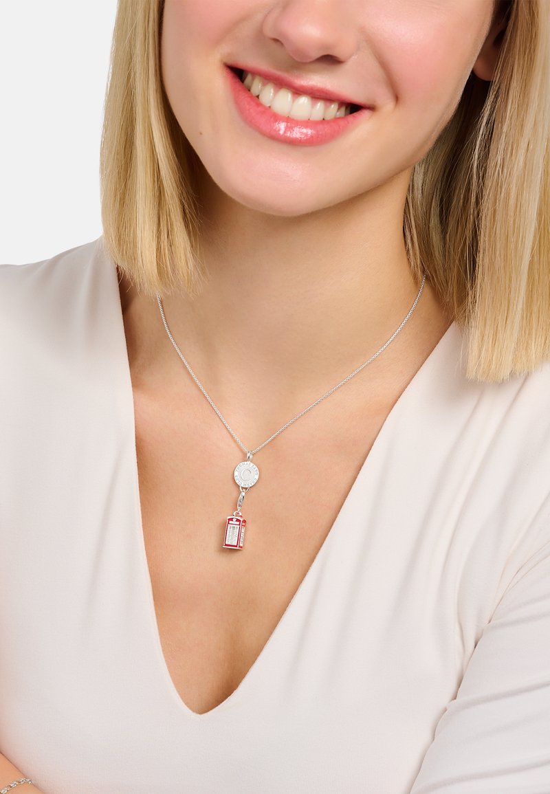 Silberne Halskette mit charmantem Kreisanhänger und einem Pendel in Form einer roten Telefonzelle. Hochglanz-Finish, zarte Kette und filigrane Details an den Anhängern.