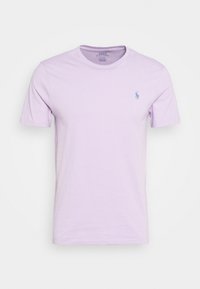 Světle fialové tričko z jemné bavlny, kulatý výstřih, krátké rukávy, na levé hrudi je malá vyšitá značka.