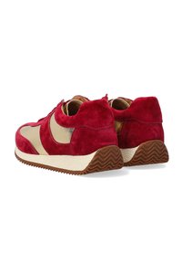 Rote Wildleder-Sneaker mit beigen Akzenten, runder Form, Schnürdesign, strukturiertem Gummisohle und subtilen Zickzack-Muster an der Unterseite.