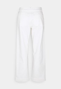 Pantalones de pierna ancha en color blanco, fabricados en algodón, con bolsillos traseros y costuras visibles. La cintura tiene un pasador para cinturón y el dobladillo está ligeramente enrollado.