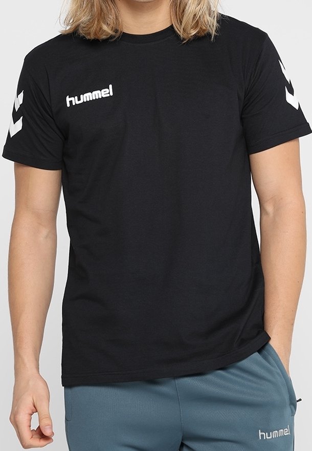 T-shirt noir à manches courtes avec logo Hummel blanc sur la poitrine et motif chevron distinctif sur les manches. Confectionné en coton doux.