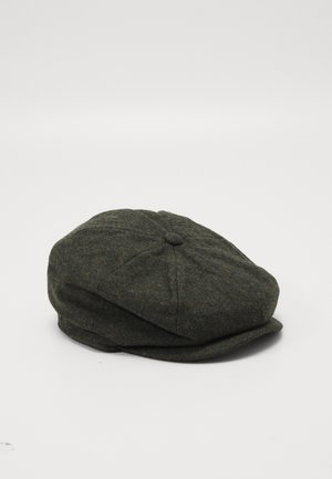 Mørkegrøn uld flat cap med syninger i panelerne og en lille knap på toppen, placeret på en hvid overflade.