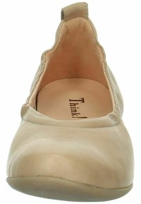 Beige Lederflachschuh mit runder Zehenpartie, weicher Textur, nahtlosem Design und kleinem Ziehschlauf hinten. Markennamen auf der Innensohle sichtbar.