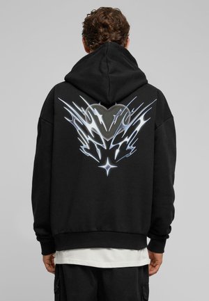 Schwarzer Hoodie mit einem grafischen Design auf der Rückseite, das silberne flammenartige Muster und eine Herzform zeigt. Hergestellt aus einem weichen Material.