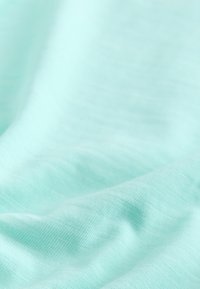 Tissu doux bleu clair avec des plis subtils et une texture fine et lisse.