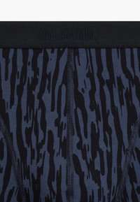 Granatowe bokserki z czarnym wzorem fal, z czarną elastyczną talią z logo 'ATLANTIC', gładka tkanina i szyte szwy.