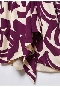Tissu violet et crème à motifs, présentant de grandes formes abstraites et un design fluide, avec une texture douce et des bords drapés.
