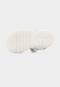 Λευκή λαστιχένια σόλα πέδιλου παιδικού με ανάγλυφη επιφάνεια για καλύτερο κράτημα και σήμανση μεγέθους "20" σε απλό λευκό φόντο.