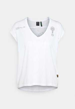 Biała koszulka z krótkim rękawem i dekoltem w serek, z małym czarnym nadrukiem tekstu i logo na piersi oraz czarno-żółtą metką przy dole.