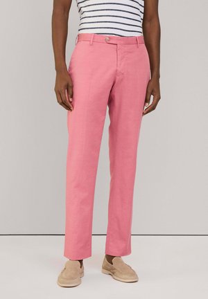 Roze katoenen broeken met een rechte pijpdesign, voorzien van een sluiting met knoop aan de voorkant en zijzakken, gecombineerd met beige schoenen.