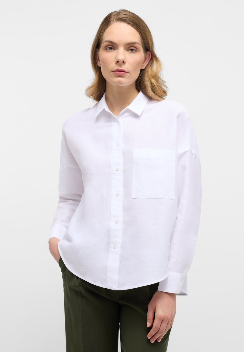 Camicia bianca con bottone, dotata di tasca sul petto, maniche lunghe e vestibilità rilassata. Realizzata in un tessuto morbido e leggero.