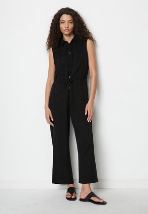Musthave mustmugav mustrippumükk, millel on nupuvajutusega esikülg, vöökoht on rõhutatud ja laiad püksisääred. Silumateks kangasteks ja minimalistlikuks disainiks.