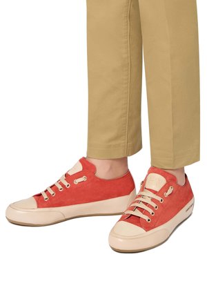 Rode suède sneakers met lichtbeige accenten en rubberen zolen. Heeft een ronde neus, vetersluiting en metalen oogjes.
