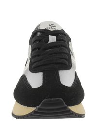 Baskets noir et blanc en suède et mesh, à bout rond, avec lacets plats et semelle en caoutchouc au grip texturé.