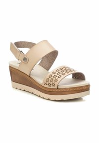 Sandalias de cuña beige con un diseño de dos correas, recortes florales, plantilla texturizada y una suela de color claro con un acento marrón.