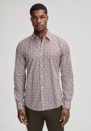 Camicia bianca con bottoni, decorata con un piccolo motivo floreale in bordeaux e viola scuro. Maniche lunghe e colletto classico; texture liscia.