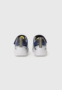 Baskets sportives avec un dessus gris et bleu, des accents en mesh, une semelle blanche et une languette jaune à l'arrière pour un enfilage facile.