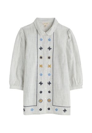 Svītrota bēškrāsas pogu kleita ar zilu, dzeltenu un melnu izšuvumu. Komplektā ir apkakle un bumbu formas piedurknes.